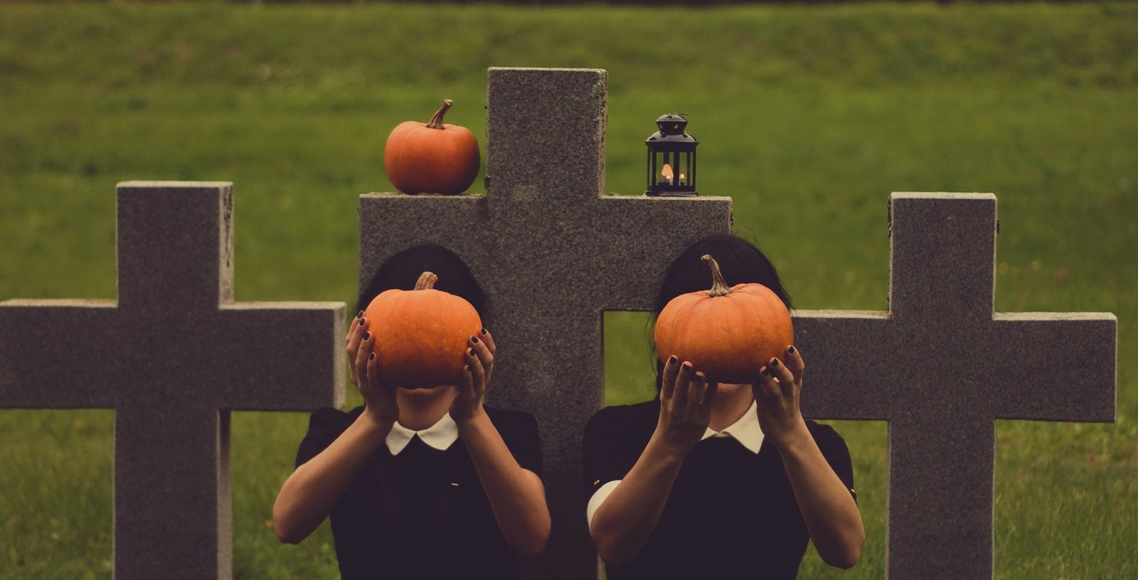 girls holding pumpkins at graves Halloween